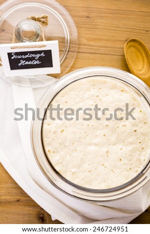 Sourdough starter in large glass jar on the table.