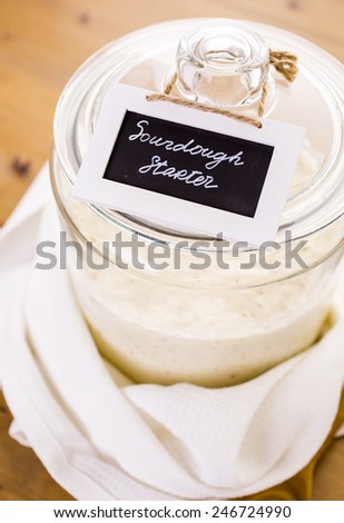 Sourdough starter in large glass jar on the table.