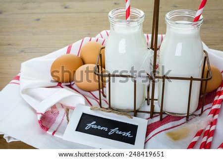 Fresh farm milk in glass jars and eggs on wood table