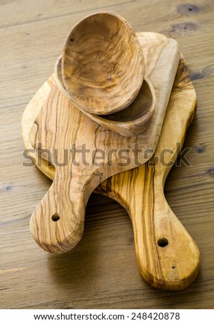 Olive wood cutting board on wood table.