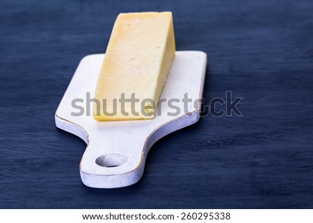 Slice of parmesan cheese on the board.