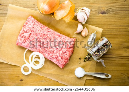 Ground pork on the table with other ingredients for recipe.