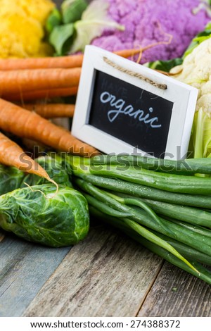 Fresh organic vegetable in season on old farm table.