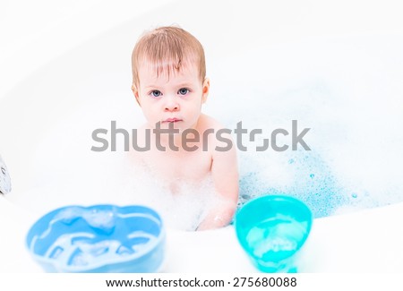 Baby girl having a good time during the bath time.