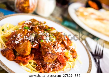 Fresh spaghetti with sausage, peppers and onions in Italian restaurant.