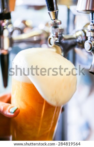 Bartender pouring draft beer in the bar.