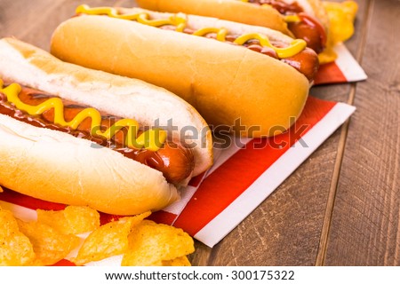 Grilled hot dogs on a white hot dog buns with mustard and ketchup.