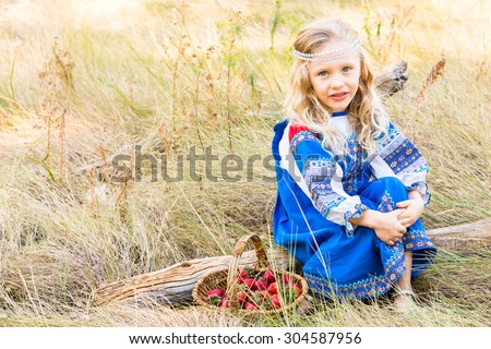 Russian children in traditional Russian costumes playing in the forest.