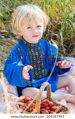 Russian children in traditional Russian costumes playing in the forest.