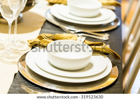 Table set with plates and silverware for Holiday dinner.