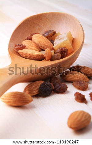 Wooden spoon full of almond nuts and raisins