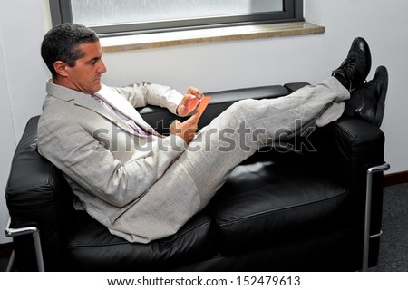 Businessman relaxing on a sofa in the office as a business concept