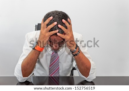 Portrait of a businessman with his hands to his head as a concept of failure in business