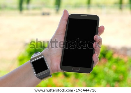 Closeup of couple smartwatch and phablet as the concept of wearable technology