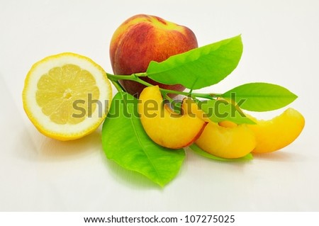 Fresh peach slices, peach, lemon and green leaves