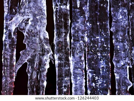 Beautiful blue icicle enlightened cold light in frost
