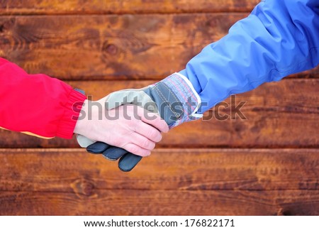 Business handshake before the new brown wooden building