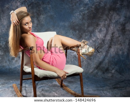 Portrait of attractive teenage girl in rocking-chair looking at the camera