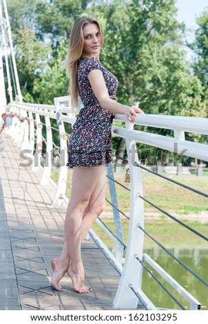 Nice young woman near a river. Portrait of an attractive young girl outdoors
