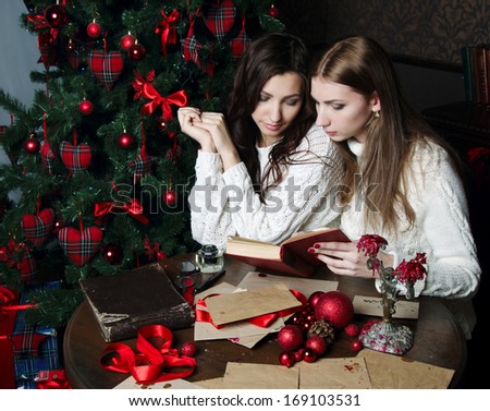 Beautiful girls in expectation of New Year reads book