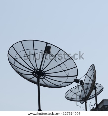 communication satellite dish on top roof over blue sky