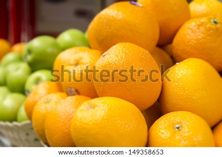 Mandarin oranges and apples in a basket, Focus on oranges