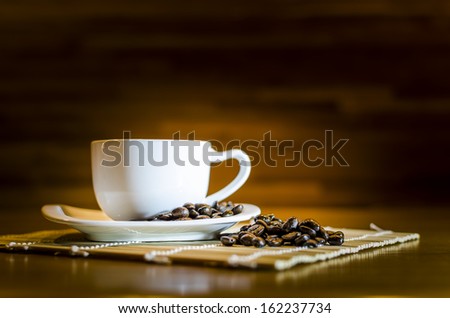 Coffee beans and white coffee cup , Focus on coffee beans
