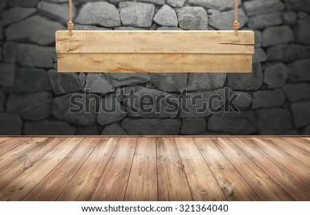Wood table with hanging wooden sign on stone wall