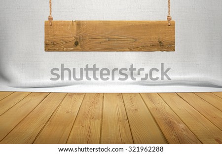 Wood table with hanging wooden sign on white fabric background