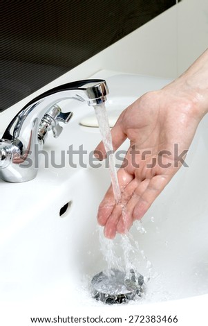 Man washes his hands in the sink