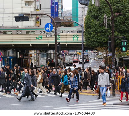 TOKYO - NOVEMBER 12: People crossing the street at Shibuya crossing in Tokyo on November 12, 2012. This location is one of busiest in Tokyo and recognized thanks to being featured in multiple films.