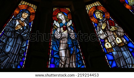 VIANA DO CASTELO, PORTUGAL - AUGUST 4, 2014: Stained glass window depicting Mother Mary and two saints in the church of Viana do Castelo, Portugal.