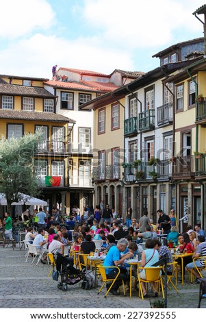 GUIMARAES, PORTUGAL - AUGUST 7, 2014: People sitting on summer terraces in the old center of Guimaraes, Portugal.