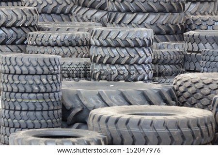 Big machines tires stack background. Industrial tires