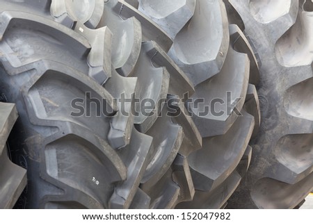 Big machines tires stack background. Industrial tires