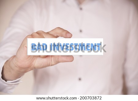 Man hands holding the words Bad Investment