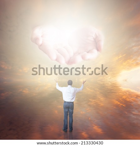 Man worshiping. The Hands of God with light coming from the sunset sky