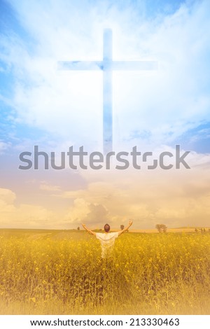 Man in the field worshiping God and the symbol of the Cross that appears in the sky