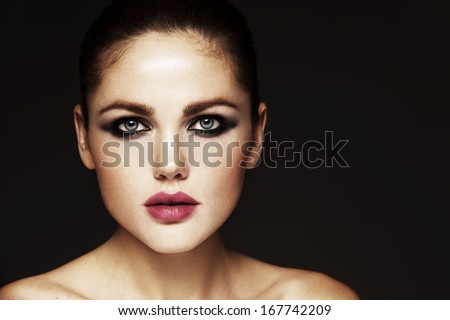 Beautiful Face Of A Glamour Woman With Smoky Eyes Make Up. Close-Up Beauty Portrait Of Young Beautiful Woman. Shooted On Black Background