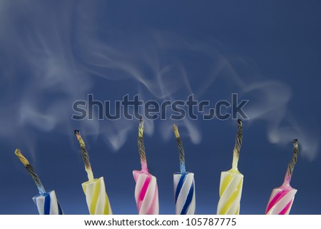 Detail of colorful birthday candles recently blown where you see the smoke.