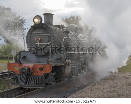 Steam train standing at the ashes pits warming up and being cleaned before taking off on a trip