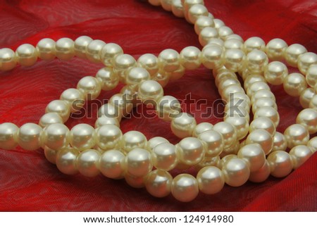 string of pearls on red fabric