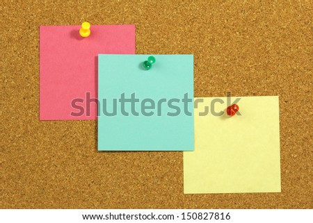 three colorful blank note cards on cork board