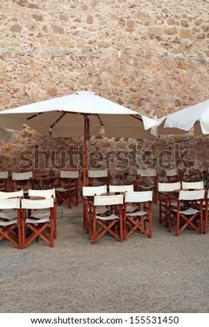 street cafe with wooden chairs and white umbrellas