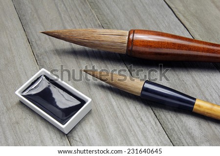 asian writing brushes and black ink for calligraphy on wooden background