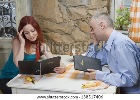 Young woman looking at menu - Undecided women - She has no idea what to order - Restaurant scene - Selective focus