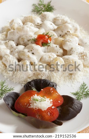 Gnocchi with white truffle sauce with garnish.