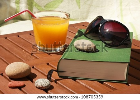 relaxing utensils in summer: book, sun glasses and juice
