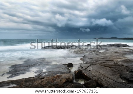 sea landscape with bad weather, rocks and rainy sky