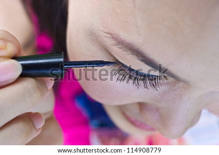 Closeup of Asian Woman Putting Mascara Makeup Eyes